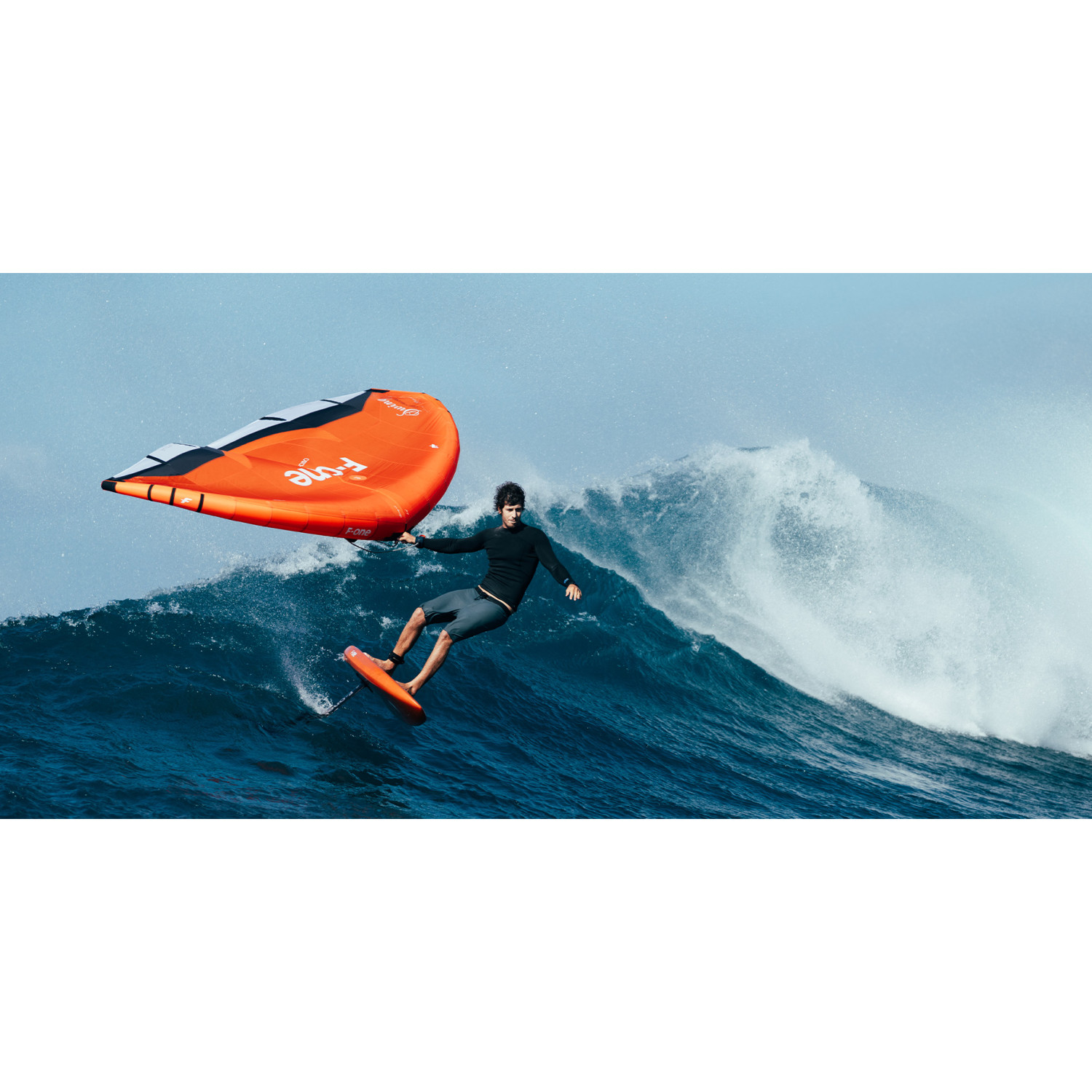 Wingfoil rider carving a wave above the water